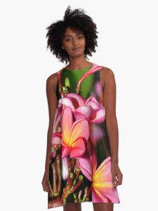 A model wearing a Plumeria Flowers Dress. Bright, and colorful facing.
